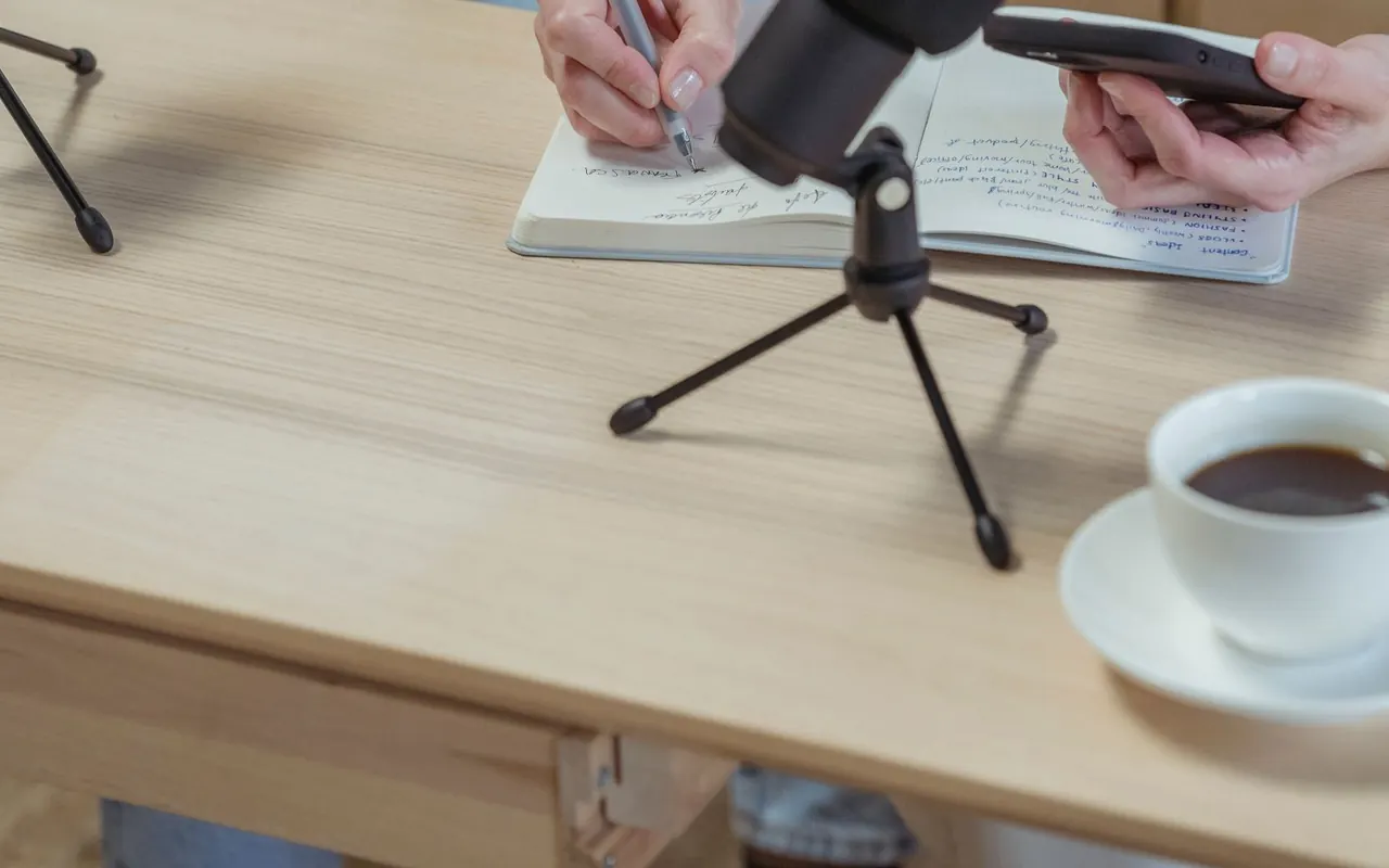 Microphone et prise de notes sur une table de préparation de podcast
